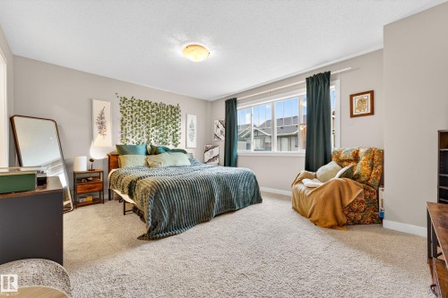 Spacious bedroom featuring light-colored walls, broad window, and plush carpet flooring - 85 165 Cy Becker Boulevard, Edmonton, AB - Indoor Photo Showing Bedroom