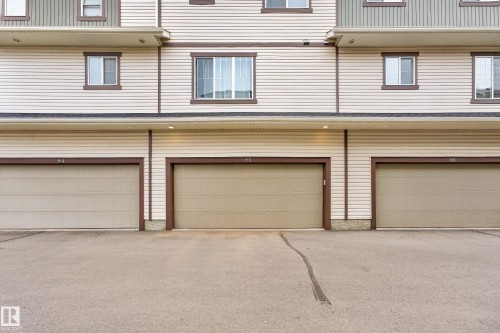 Three individual garage doors with brown trim - 85 165 Cy Becker Boulevard, Edmonton, AB - Outdoor With Exterior