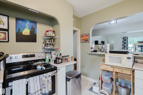 Kitchen featuring a stainless steel range and light countertops - 11158 65 Street, Edmonton, AB 