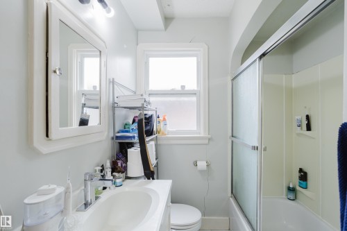 Bathroom featuring a white vanity with an integrated sink, polished chrome faucet, and a wall-mounted medicine cabinet with a mirror - 11158 65 Street, Edmonton, AB 