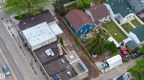 Aerial perspective showcasing multiple residential properties with varied rooflines and a commercial building - 11158 65 Street, Edmonton, AB 