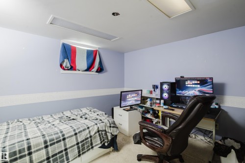 Room featuring light purple walls with a textured white accent strip, recessed lighting fixtures, and a window opening - 11158 65 Street, Edmonton, AB 