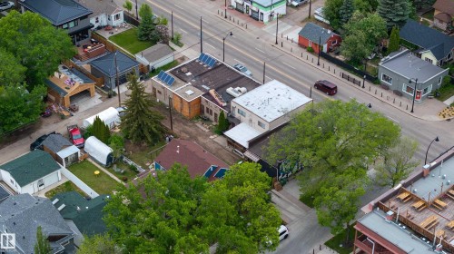 Aerial perspective of a multi-building property featuring a flat roof structure with solar panels, an adjacent building with a dark-pitched roof, and a third building with a light-colored flat roof - 11158 65 Street, Edmonton, AB 