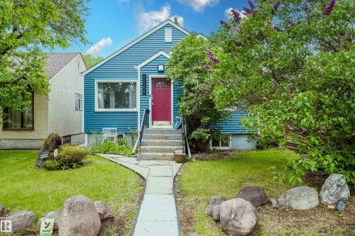Blue siding exterior with a contrasting red entry door - 11158 65 Street, Edmonton, AB 