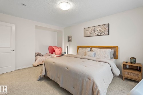 Carpeted bedroom featuring white walls and a built-in recessed area - 20227 17Ave, Edmonton, AB 