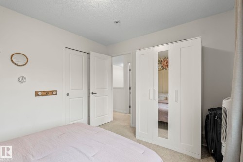 White paneled doors, neutral carpeting, and a built-in wardrobe with mirrored panels - 20227 17Ave, Edmonton, AB 