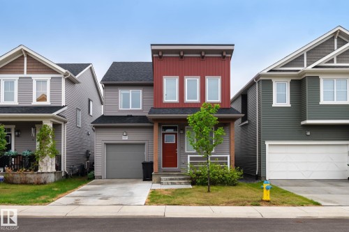 Modern residential facade featuring red vertical siding and gray horizontal siding - 20227 17Ave, Edmonton, AB 