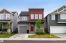 Modern residential facade featuring red vertical siding and gray horizontal siding - 20227 17Ave, Edmonton, AB 