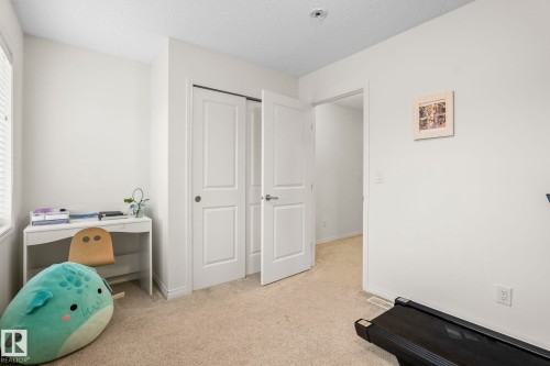 Room featuring neutral carpeting, white walls, and a window with blinds - 20227 17Ave, Edmonton, AB 