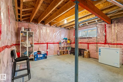 Unfinished basement offering exposed wood framing, concrete flooring, and an egress window - 20227 17Ave, Edmonton, AB 