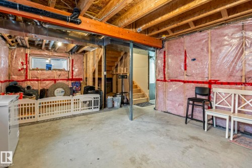 Unfinished basement space featuring exposed wooden joists, concrete flooring, and insulated walls - 20227 17Ave, Edmonton, AB 