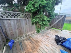 Wood-finish deck with a perimeter wood fence featuring a lattice top - 