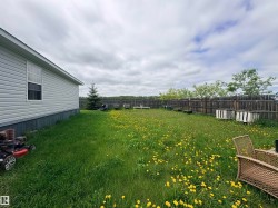 Expansive grassy yard area with a wood privacy fence - 
