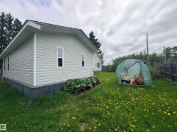 Light green horizontal siding exterior with white window trim and a dark gray shingle roof - 