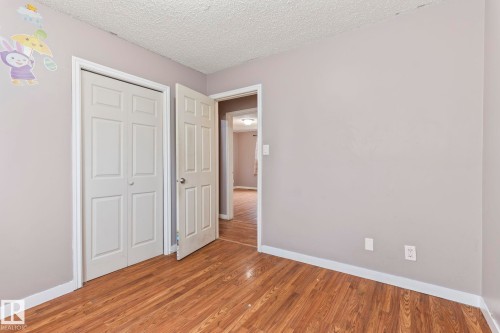 Neutral gray wall paint with white trim, wood-finish flooring, and white paneled doors - 2045 46St, Edmonton, AB 
