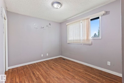 Room featuring wood-finish flooring, light grey walls, and white trim - 2045 46St, Edmonton, AB 