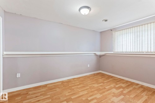 Room featuring wood-finish flooring, light grey painted walls, and white trim - 2045 46St, Edmonton, AB 