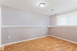 Room featuring wood-finish flooring, light grey painted walls, and white trim - 