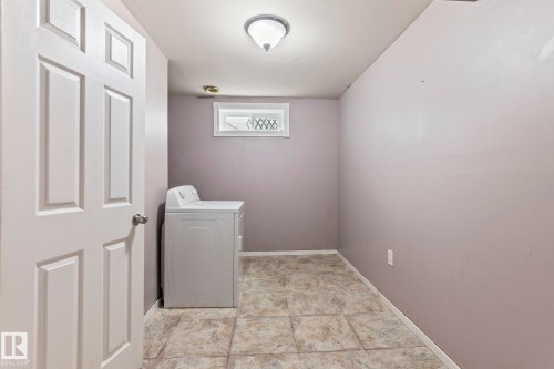 Utility space featuring large format square floor tiles, a window with decorative grates, and a flush mount ceiling light fixture - 2045 46St, Edmonton, AB 