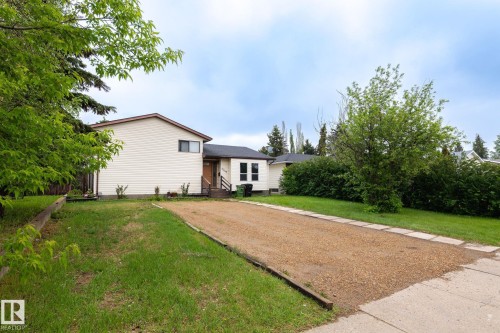 Single-story residence featuring light-colored siding and a brown-trimmed roofline - 2045 46St, Edmonton, AB 