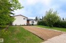 Single-story residence featuring light-colored siding and a brown-trimmed roofline - 2045 46St, Edmonton, AB 