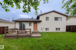 Rear exterior featuring light-colored horizontal siding and a brown shingle roof - 