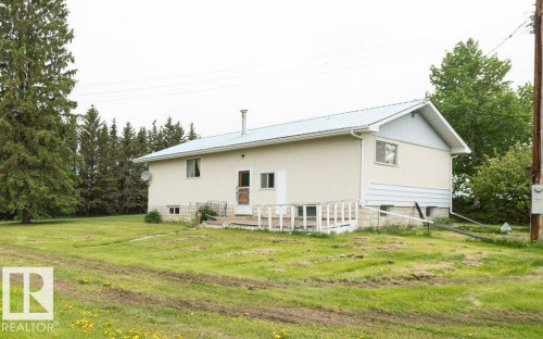 White stucco exterior with a light blue metal roof and matching gable accents - 2021 Twp Rd 604, Rural Westlock County, AB 