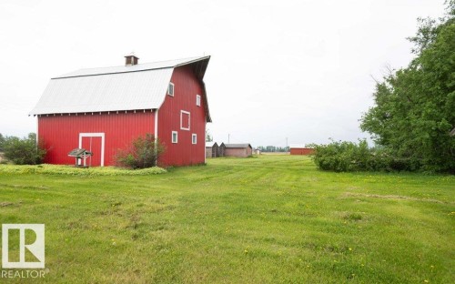 Red barn structure featuring a gambrel roof and bright white trim - 2021 Twp Rd 604, Rural Westlock County, AB 