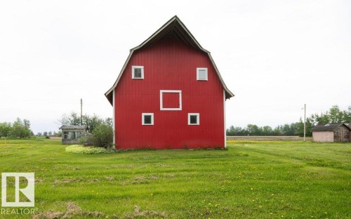 Red barn with a gambrel roof and white trim detailing - 2021 Twp Rd 604, Rural Westlock County, AB 