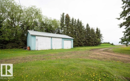 Detached structure featuring a light blue and white exterior, two garage doors, and a metal roof - 2021 Twp Rd 604, Rural Westlock County, AB 