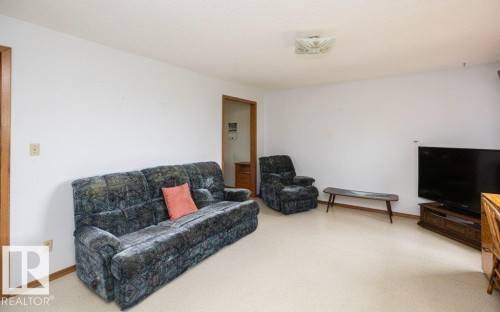 Living area featuring neutral wall paint, light-colored carpeting, and wood-finish door frames and trim - 2021 Twp Rd 604, Rural Westlock County, AB 