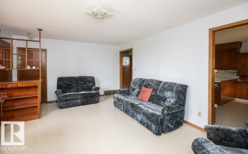 Interior room featuring wood-finish accent shelving, a built-in wood-finish bar, and light-toned flooring - 2021 Twp Rd 604, Rural Westlock County, AB 