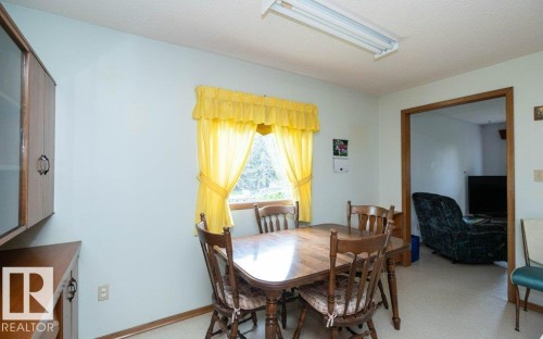 Kitchenette with light-toned walls, wood-finish trim, and an overhead fluorescent light fixture - 2021 Twp Rd 604, Rural Westlock County, AB 