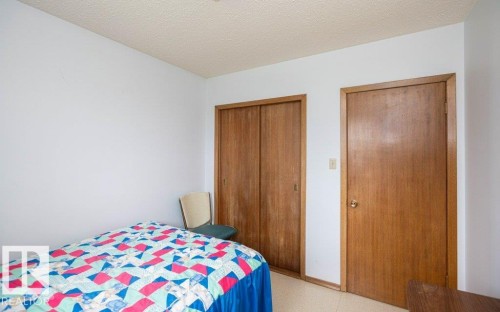 Bedroom featuring light-colored walls, wood-finish doors, and a textured ceiling - 2021 Twp Rd 604, Rural Westlock County, AB 