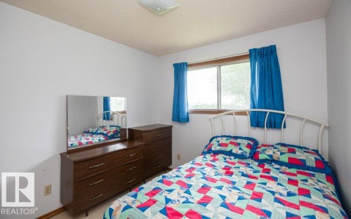 Bedroom featuring a window with natural light, light-colored walls, and wood-finish flooring - 2021 Twp Rd 604, Rural Westlock County, AB 