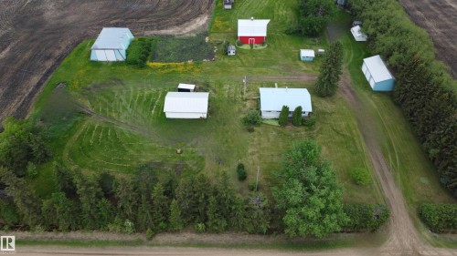 Expansive rural property featuring a main residence, multiple outbuildings, mature tree lines, and surrounding agricultural fields - 2021 Twp Rd 604, Rural Westlock County, AB 