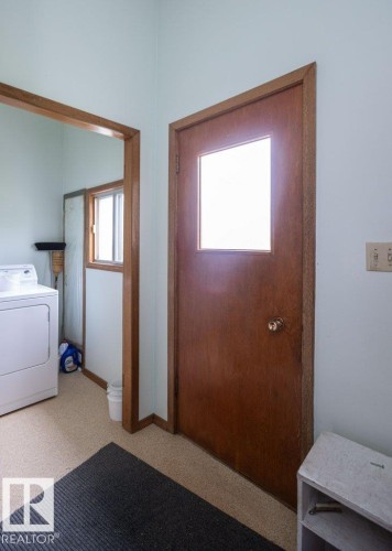 Entryway featuring a wood-panel door with privacy glass, complemented by light-colored walls and carpeted flooring - 2021 Twp Rd 604, Rural Westlock County, AB 