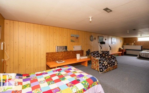Spacious interior with wood-paneled walls, a drop ceiling, and grey carpet flooring - 2021 Twp Rd 604, Rural Westlock County, AB 