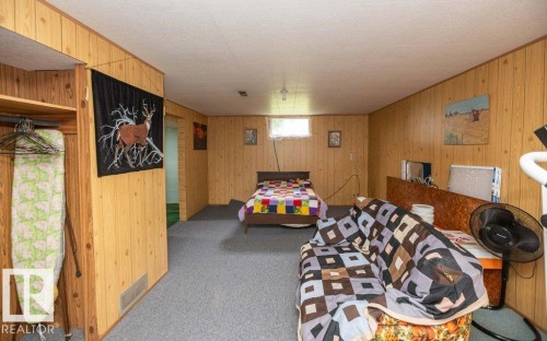 Room featuring wood-finish paneling, gray carpet flooring, and a single window - 2021 Twp Rd 604, Rural Westlock County, AB 