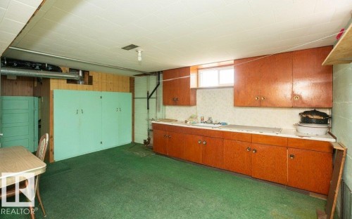 Lower-level space featuring wood-finish cabinetry, a white countertop, and a single-basin sink - 2021 Twp Rd 604, Rural Westlock County, AB 