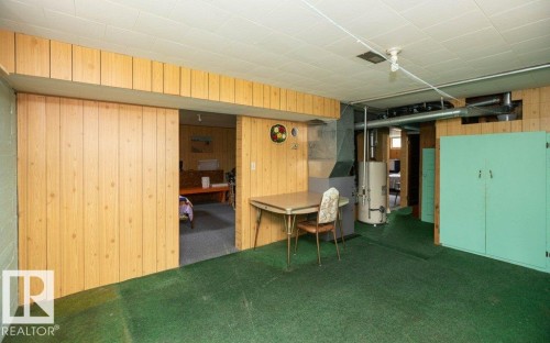 Finished basement area featuring wood-panel walls, green carpeting, and a drop ceiling - 2021 Twp Rd 604, Rural Westlock County, AB 