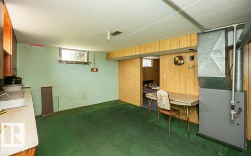 Carpeted room with a drop ceiling, featuring a window and built-in cabinetry with a countertop - 2021 Twp Rd 604, Rural Westlock County, AB 