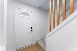 Entryway featuring a paneled door with decorative glass, digital lock, and wood-finish flooring - 