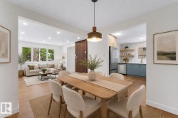 Dining area featuring a wood-finish table with upholstered chairs, a contemporary pendant light, and wood-finish flooring - 