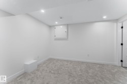 Spacious room featuring light-colored carpeting, white baseboards, and recessed lighting - 