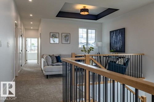 Upper-level area featuring a tray ceiling with a dark accent, a contemporary drum pendant light, and recessed lighting - 82 Wynn Rd, Fort Saskatchewan, AB 
