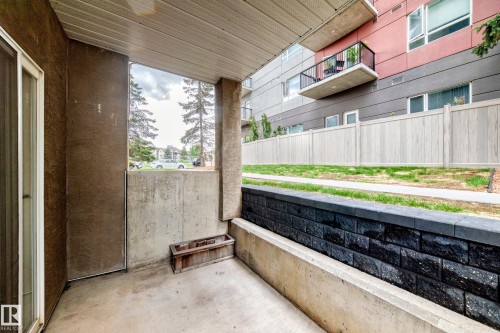 Private concrete patio featuring a sliding glass door - 126 10535 122 Street, Edmonton, AB 