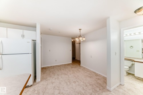 Open-concept living area with neutral wall tones and light-toned flooring - 126 10535 122 Street, Edmonton, AB 