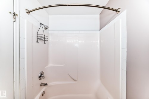 White fiberglass tub/shower combination with a curved shower rod - 126 10535 122 Street, Edmonton, AB 