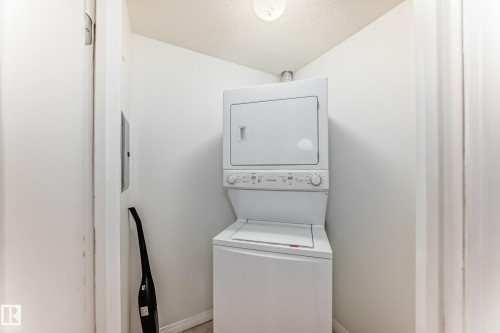 Dedicated in-suite  laundry featuring a white stacked washer and dryer unit - 126 10535 122 Street, Edmonton, AB 